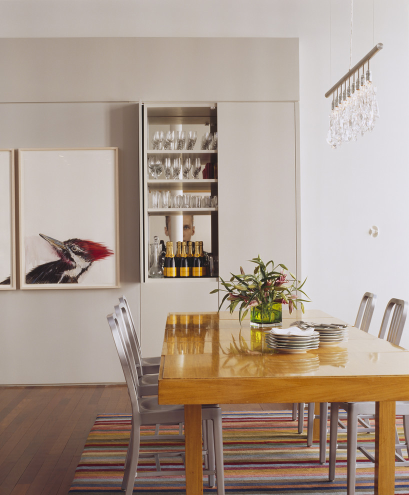 Diseño de comedor contemporáneo con paredes blancas y suelo de madera oscura