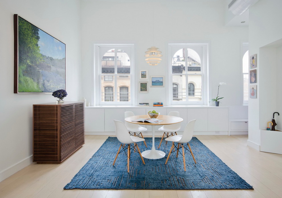 На фото: гостиная-столовая в скандинавском стиле с белыми стенами и светлым паркетным полом