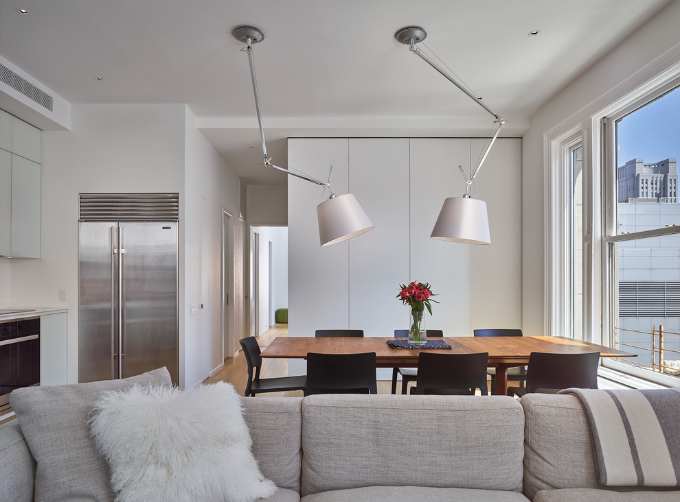 Ispirazione per una sala da pranzo aperta verso la cucina moderna di medie dimensioni con pareti bianche
