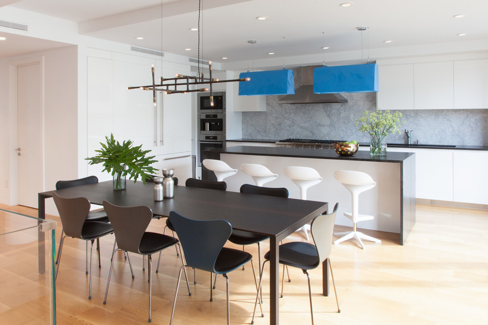 На фото: кухня-столовая среднего размера в стиле модернизм с светлым паркетным полом, белыми стенами и коричневым полом без камина