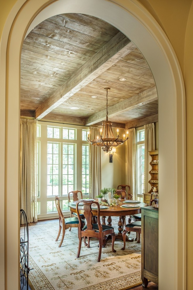 Diseño de comedor de estilo americano grande cerrado con paredes beige, suelo de madera oscura, suelo marrón y vigas vistas