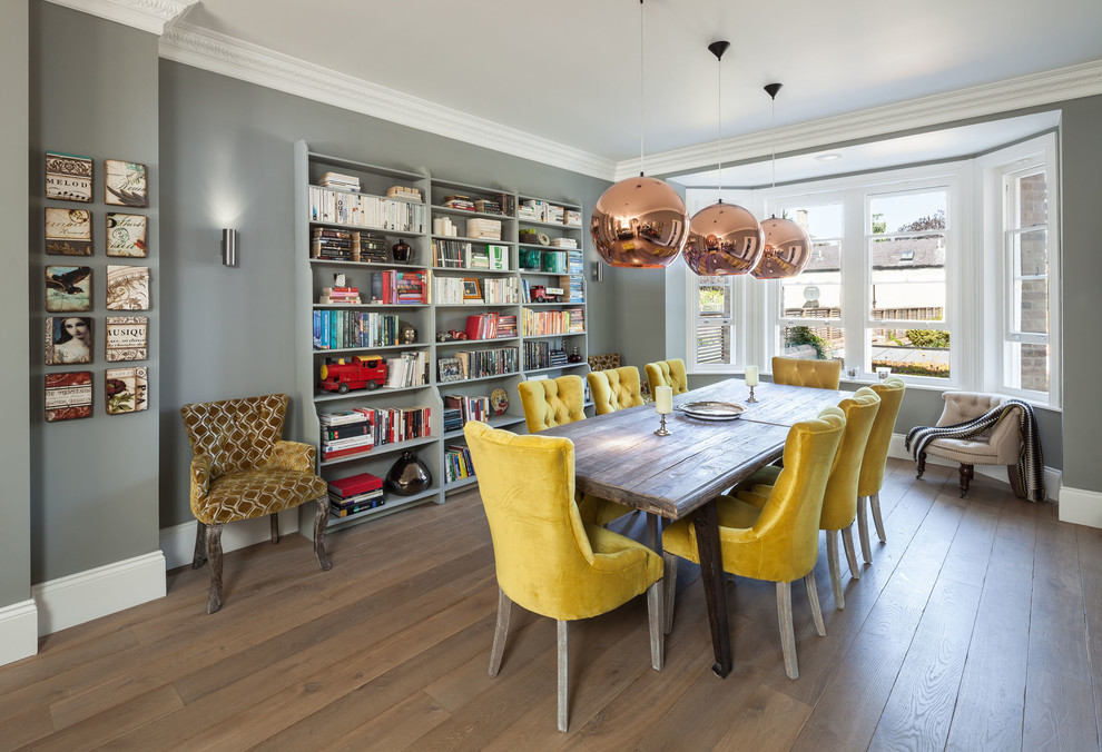 Example of a mid-sized classic medium tone wood floor dining room design in Oxfordshire with gray walls and no fireplace