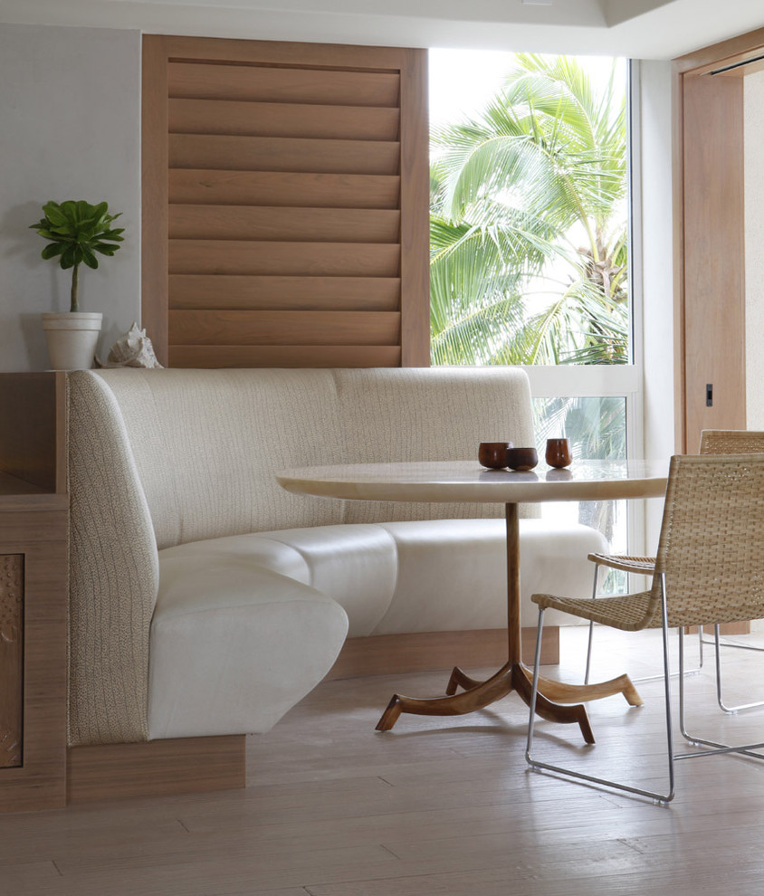 Aménagement d'une salle à manger exotique avec un mur blanc, un sol en bois brun et un sol beige.