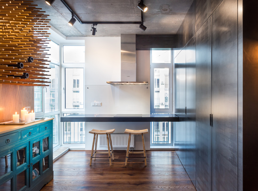 Industrial Wohnküche ohne Kamin mit grauer Wandfarbe und dunklem Holzboden in Sonstige