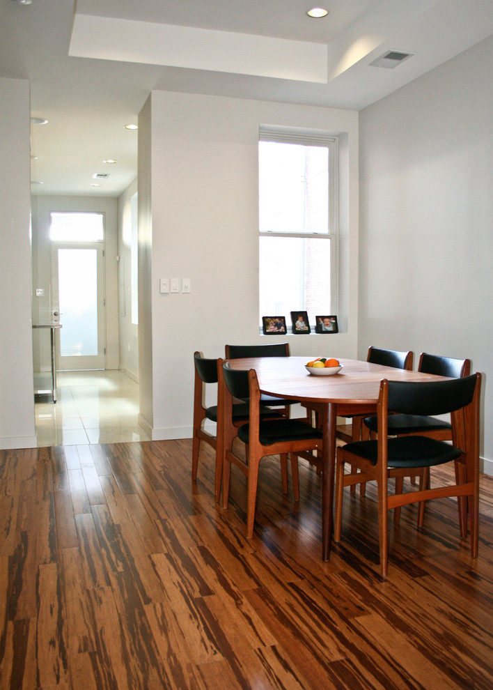 Cette photo montre une petite salle à manger moderne avec parquet en bambou, un mur blanc et aucune cheminée.