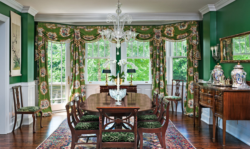 Modelo de comedor clásico con paredes verdes, suelo de madera oscura y cortinas