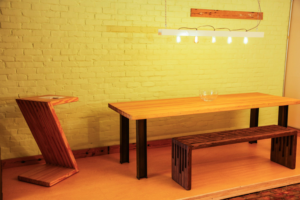 Ejemplo de comedor minimalista de tamaño medio cerrado sin chimenea con paredes amarillas, suelo de madera pintada y suelo marrón