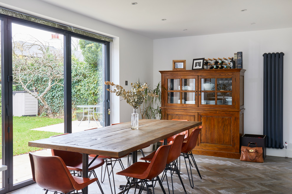 Große Moderne Wohnküche ohne Kamin mit weißer Wandfarbe, hellem Holzboden und braunem Boden in London