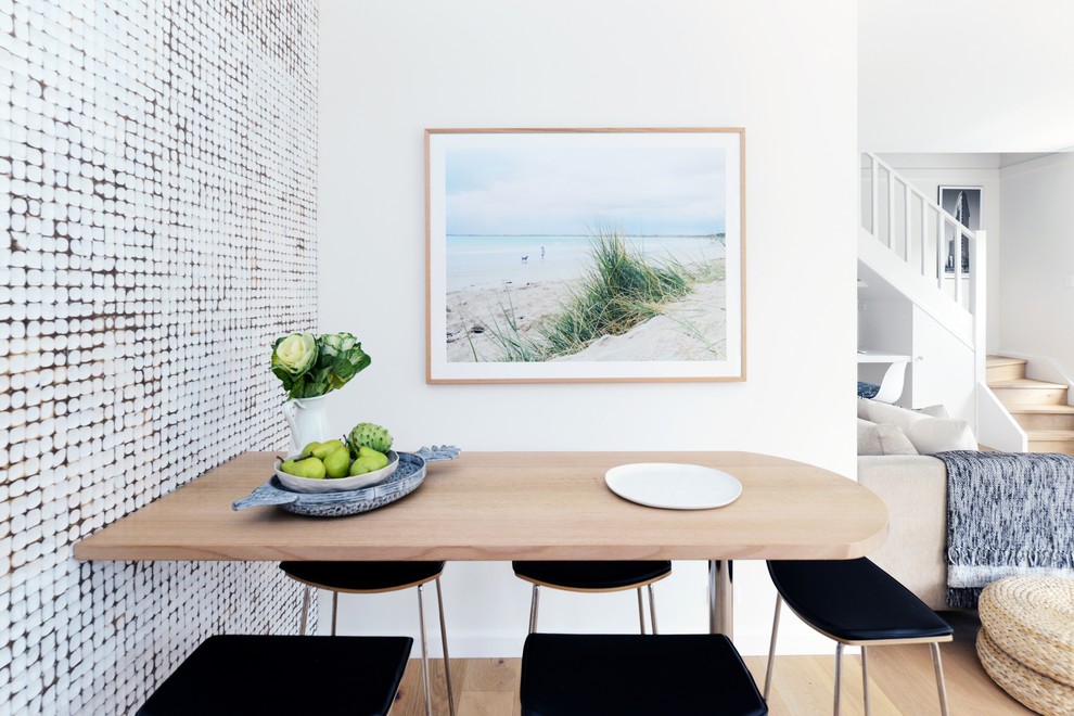 Esempio di una grande sala da pranzo costiera con pareti bianche, parquet chiaro e pavimento beige