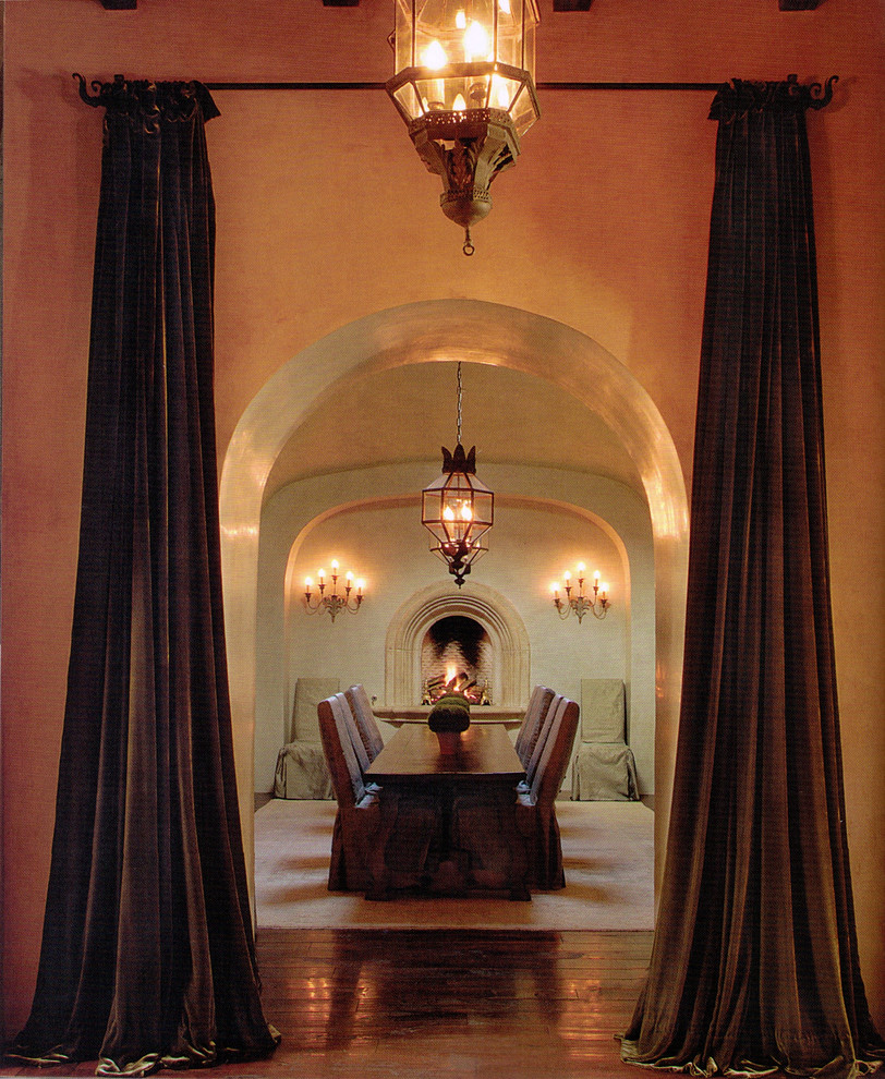 Cette photo montre une grande salle à manger méditerranéenne fermée avec un mur beige, parquet foncé, une cheminée standard et un manteau de cheminée en pierre.