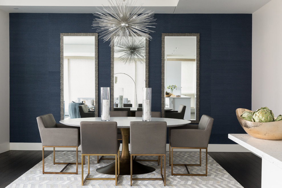 Cette image montre une salle à manger design avec un mur bleu, parquet foncé, aucune cheminée et éclairage.
