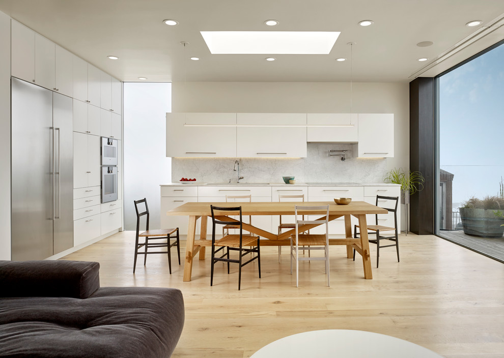 Idee per una sala da pranzo aperta verso la cucina contemporanea di medie dimensioni con pareti bianche, pavimento in laminato e pavimento marrone