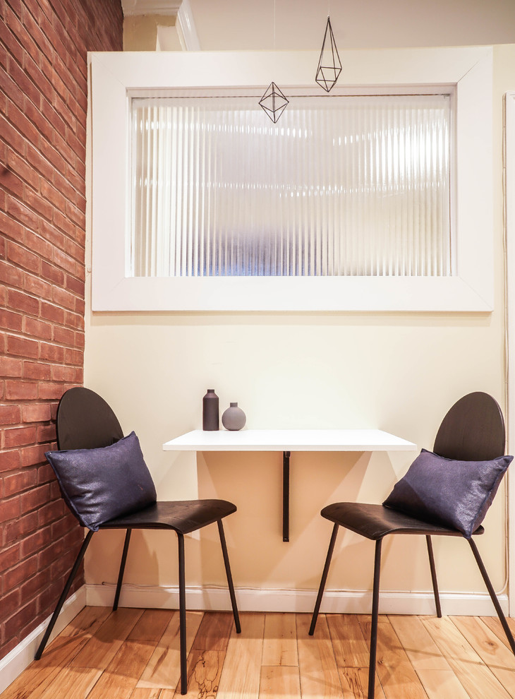Idées déco pour une petite salle à manger ouverte sur la cuisine moderne avec un mur beige, parquet clair et un sol marron.