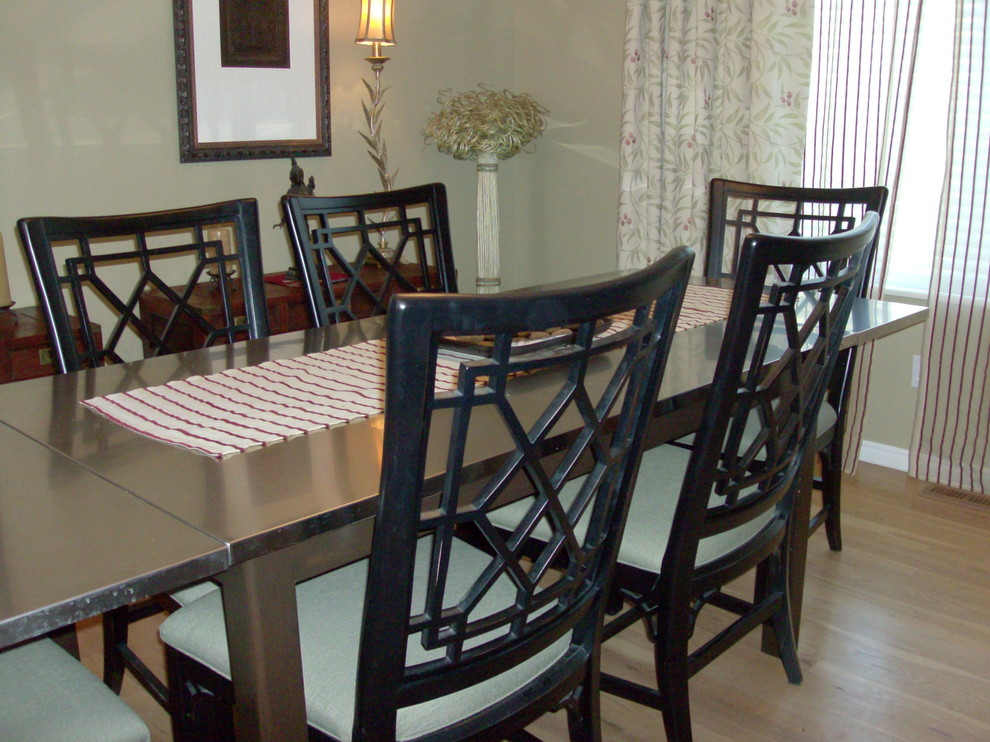 Foto på en mellanstor eklektisk separat matplats, med gröna väggar, mellanmörkt trägolv, en standard öppen spis, en spiselkrans i trä och beiget golv