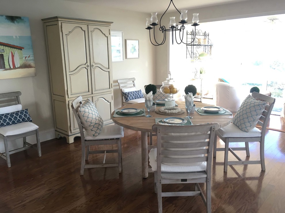 Esempio di una sala da pranzo aperta verso la cucina costiera di medie dimensioni con pareti bianche, pavimento in legno massello medio e pavimento marrone