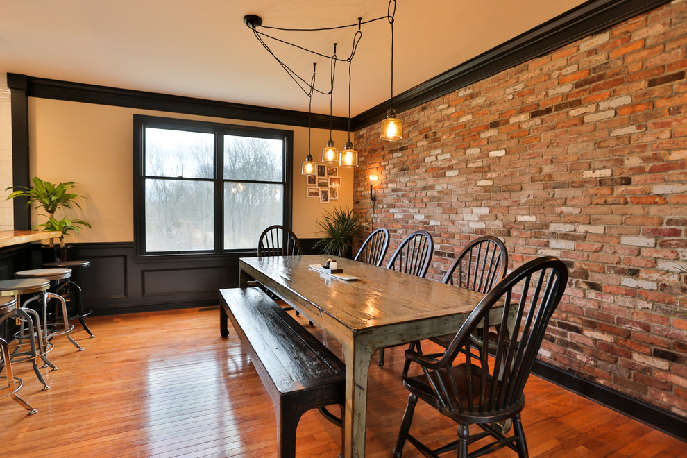 Réalisation d'une salle à manger ouverte sur la cuisine champêtre de taille moyenne avec un mur multicolore, un sol en bois brun, aucune cheminée et un sol marron.