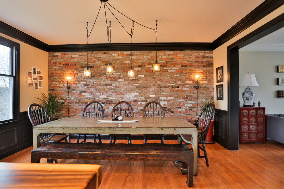 Exemple d'une salle à manger ouverte sur la cuisine nature de taille moyenne avec un mur multicolore, un sol en bois brun, aucune cheminée et un sol marron.