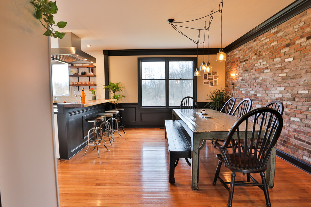 Mittelgroße Landhausstil Wohnküche ohne Kamin mit bunten Wänden, braunem Holzboden und braunem Boden in New York