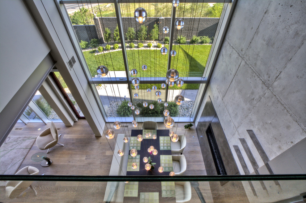 Стильный дизайн: гостиная-столовая среднего размера в современном стиле с серыми стенами, паркетным полом среднего тона, горизонтальным камином, фасадом камина из металла и коричневым полом - последний тренд