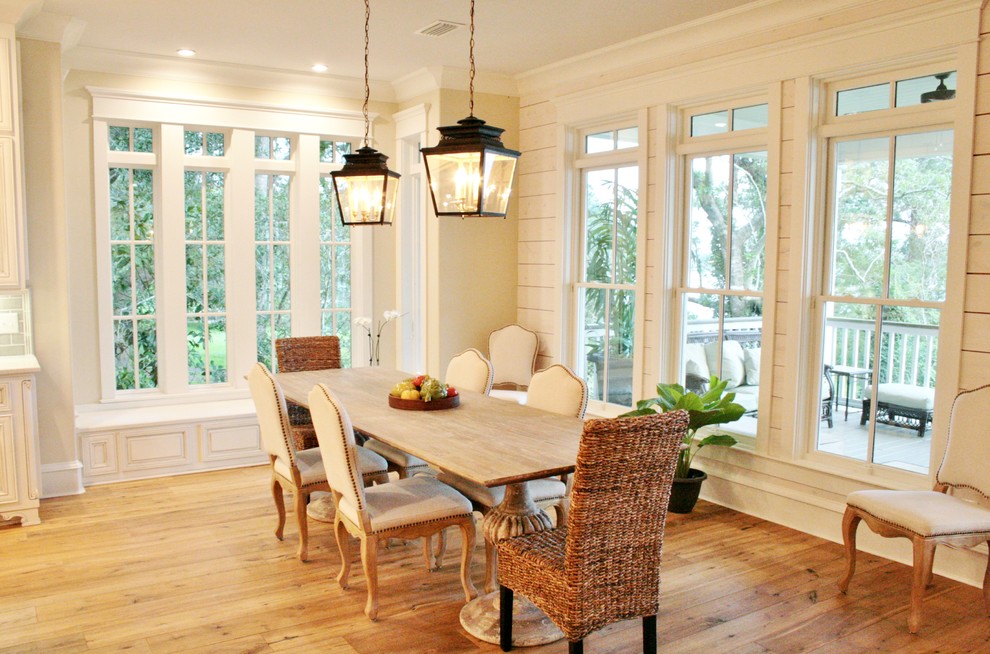 Foto di una sala da pranzo aperta verso la cucina con pareti beige, parquet chiaro e nessun camino
