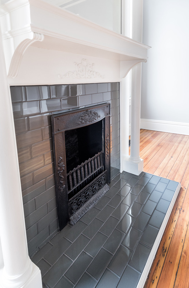 ウィルミントンにある広いエクレクティックスタイルのおしゃれなLDK (グレーの壁、淡色無垢フローリング、標準型暖炉、レンガの暖炉まわり) の写真