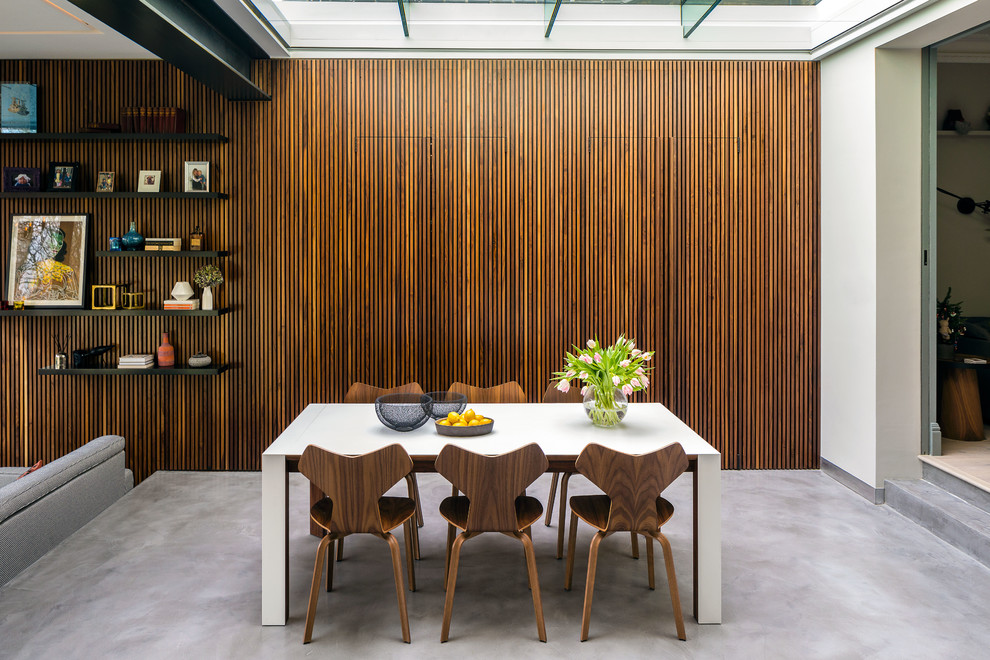 Inspiration for a contemporary dining room in London with white walls, concrete flooring and grey floors.