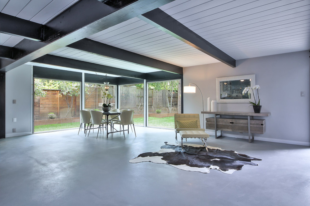 Great room - large 1960s concrete floor and gray floor great room idea in Other with gray walls and no fireplace