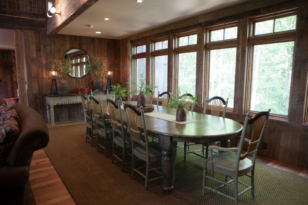 Exemple d'une salle à manger ouverte sur le salon montagne de taille moyenne avec un mur marron, un sol en bois brun, aucune cheminée et un sol marron.