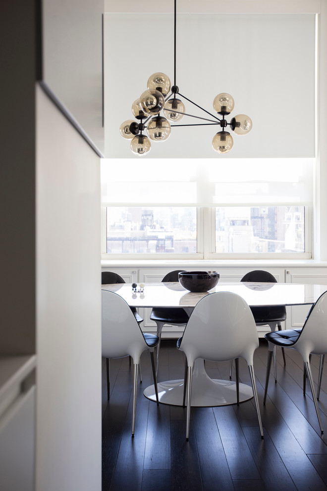 Idée de décoration pour une salle à manger design avec un mur blanc et parquet foncé.