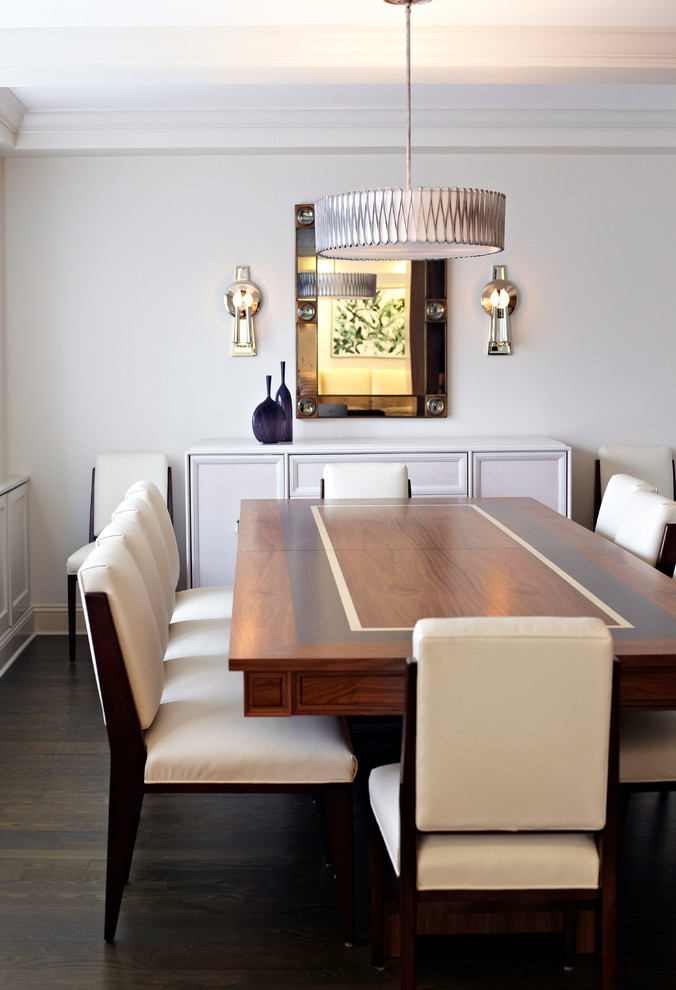 This is an example of a traditional dining room in New York with white walls and dark hardwood flooring.