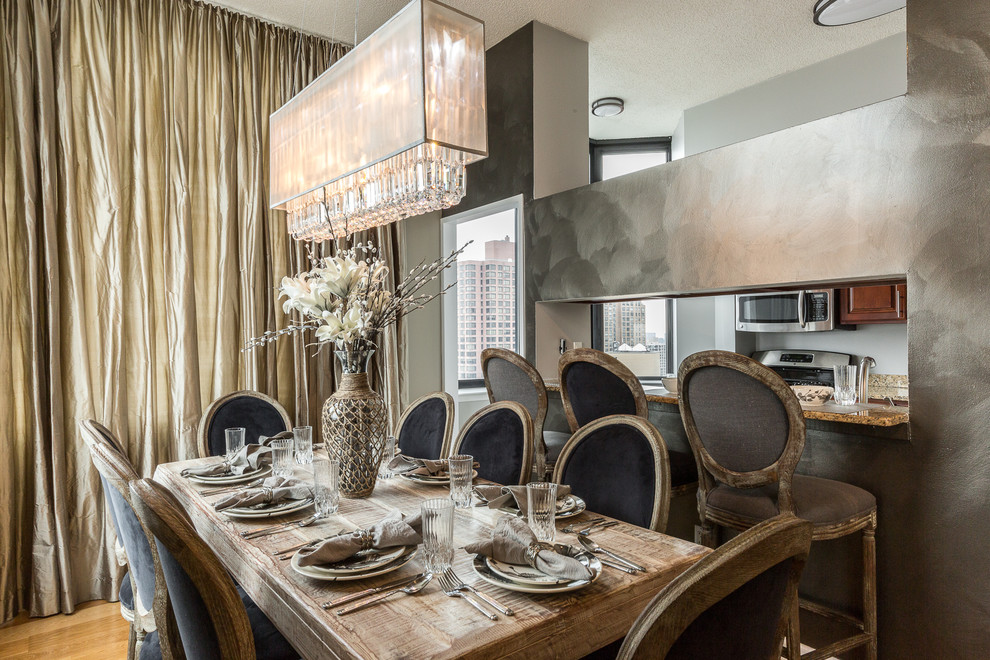 Immagine di una piccola sala da pranzo aperta verso la cucina stile shabby con pareti con effetto metallico e pavimento in legno massello medio