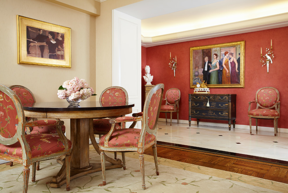Immagine di una grande sala da pranzo classica con pareti rosse, nessun camino e pavimento in legno massello medio