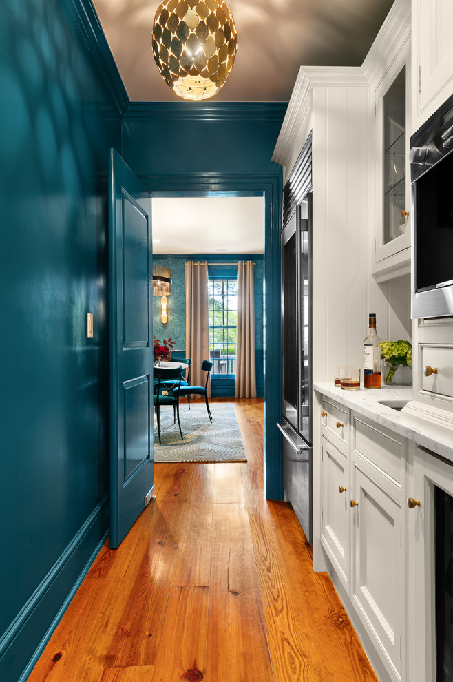 Mittelgroßes Modernes Esszimmer mit blauer Wandfarbe, braunem Holzboden und Tapetenwänden in New York