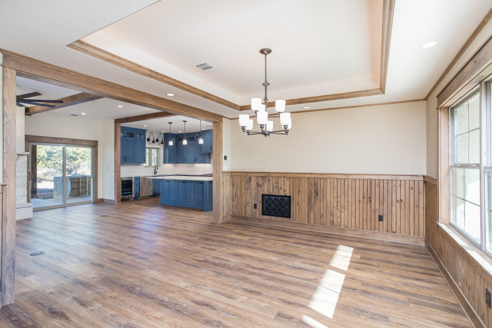 Foto di una sala da pranzo aperta verso il soggiorno stile americano di medie dimensioni con pareti beige, pavimento in vinile e pavimento marrone