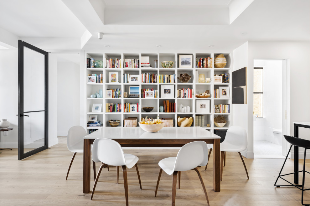 Idee per una sala da pranzo aperta verso la cucina minimal con pareti bianche, parquet chiaro e pavimento beige