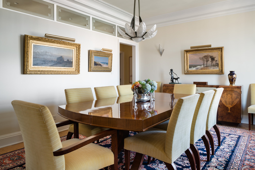 Example of a classic medium tone wood floor and brown floor dining room design with beige walls