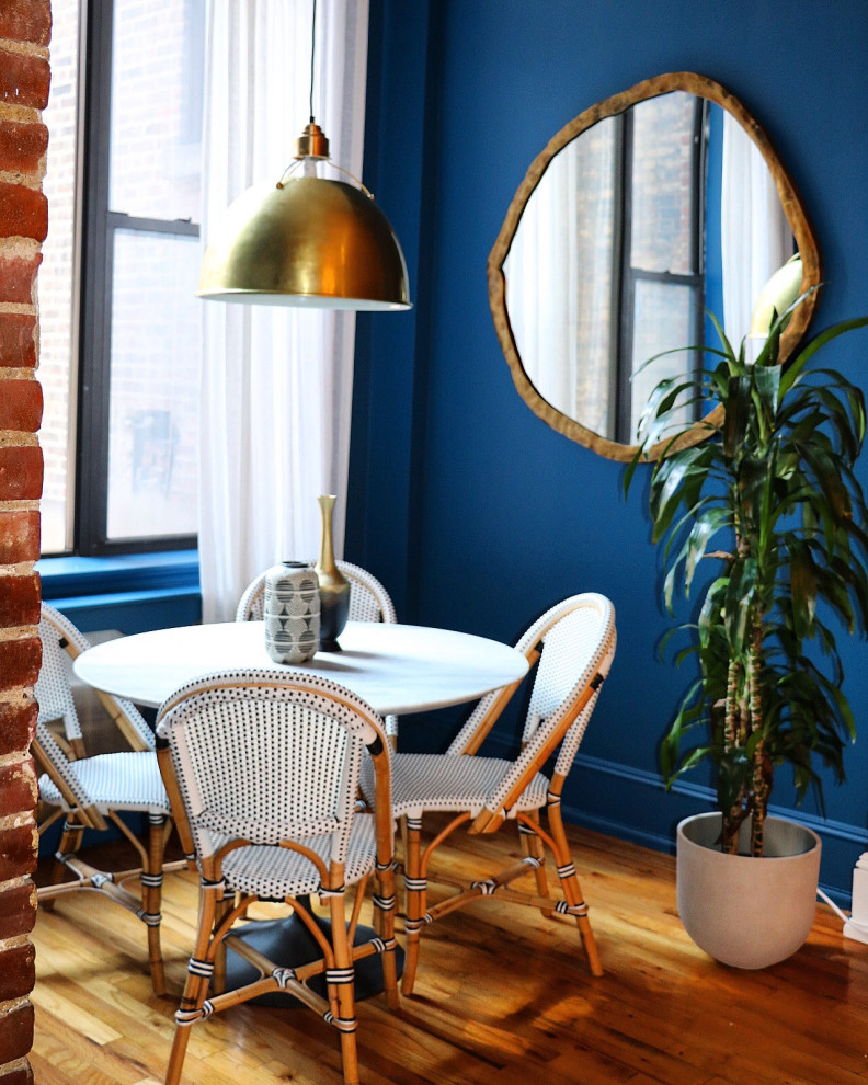 Ispirazione per un angolo colazione eclettico di medie dimensioni con pareti blu e pavimento in legno massello medio