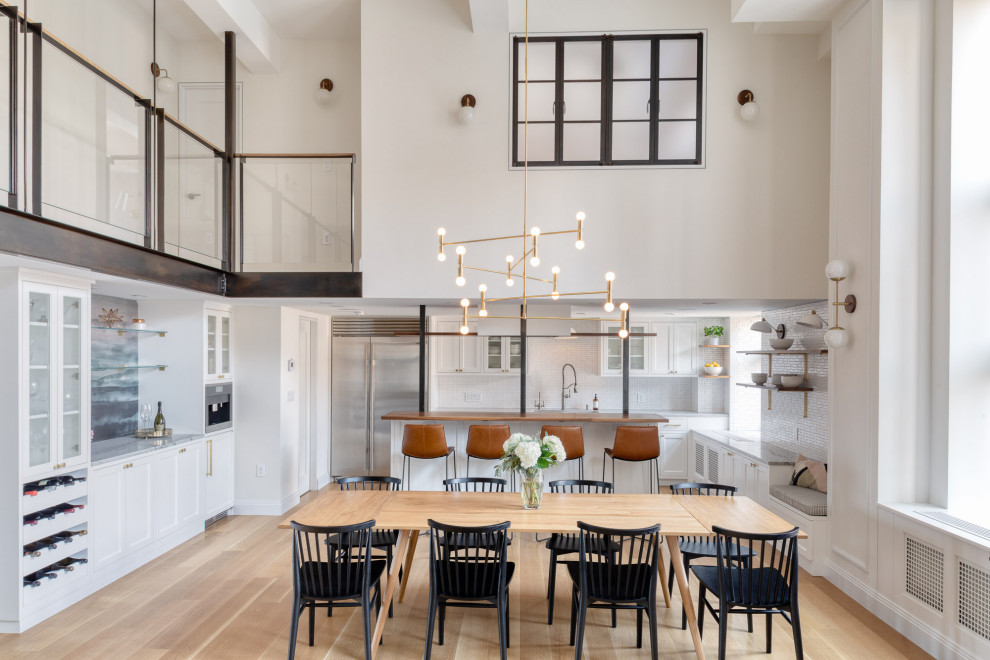Ispirazione per una grande sala da pranzo aperta verso la cucina tradizionale con pareti bianche, parquet chiaro e pavimento marrone