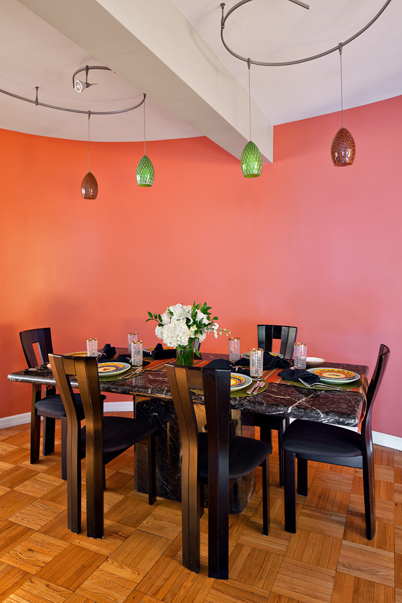 Idées déco pour une salle à manger contemporaine fermée et de taille moyenne avec parquet clair, aucune cheminée et un mur rose.