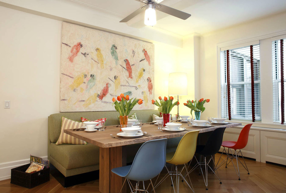 Immagine di una grande sala da pranzo aperta verso la cucina eclettica con pareti gialle e parquet chiaro