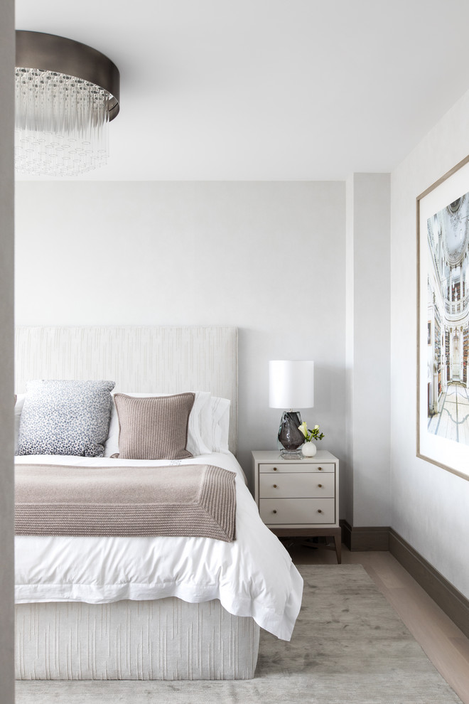 Foto de dormitorio contemporáneo con paredes blancas, suelo de madera clara y suelo beige