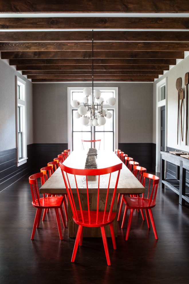 Ispirazione per una grande sala da pranzo aperta verso la cucina country con pareti nere, parquet scuro e pavimento marrone