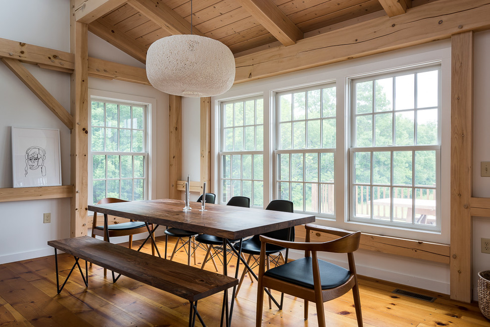 Foto di una sala da pranzo aperta verso il soggiorno country di medie dimensioni con pareti bianche e pavimento in legno massello medio