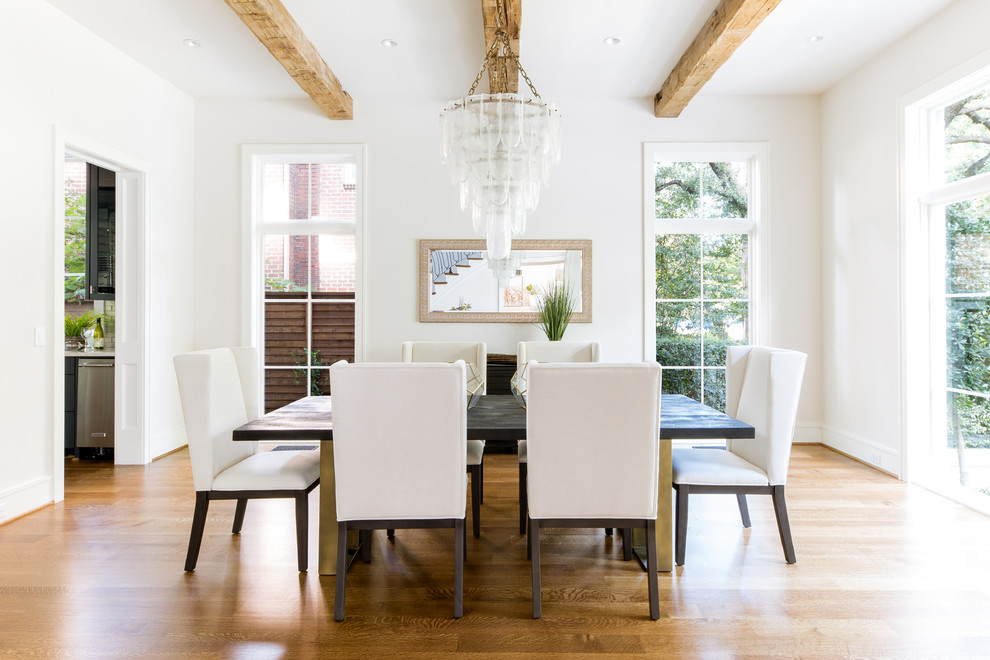 Idée de décoration pour une salle à manger tradition fermée avec un mur blanc et un sol en bois brun.