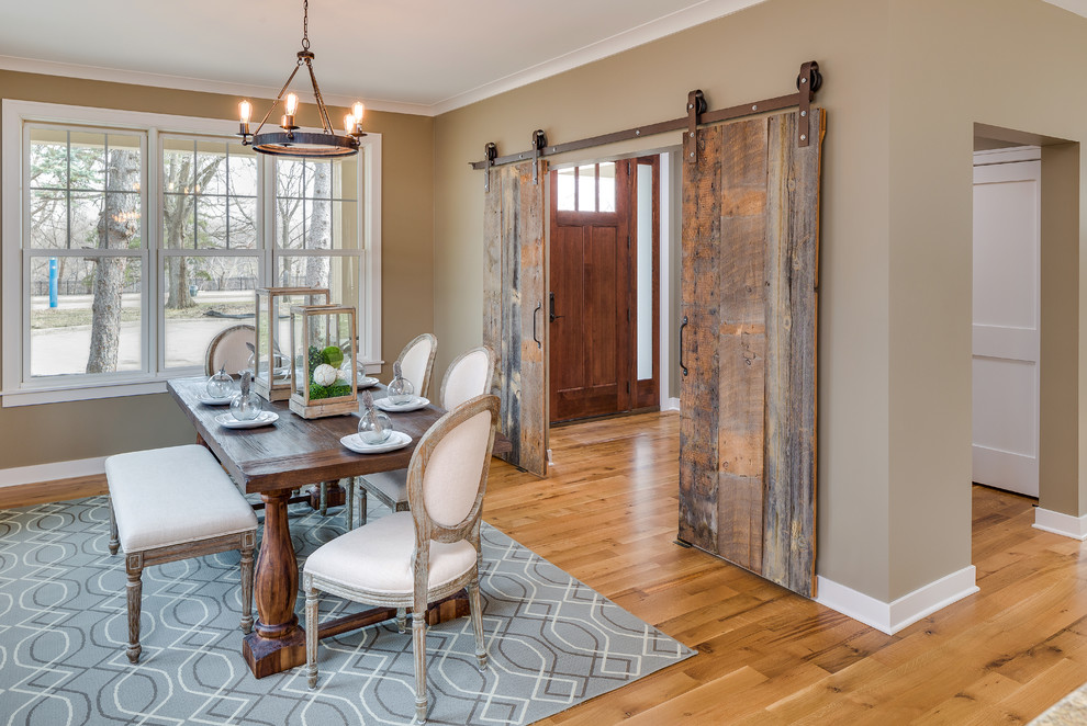 Esempio di una sala da pranzo aperta verso la cucina american style di medie dimensioni con pareti beige e pavimento in legno massello medio