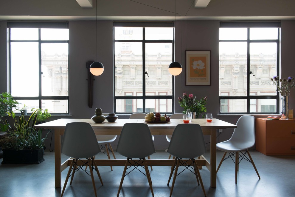 Ispirazione per una sala da pranzo aperta verso la cucina industriale di medie dimensioni con pareti grigie, pavimento in cemento e nessun camino