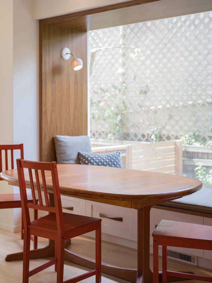 Foto di una sala da pranzo aperta verso la cucina chic di medie dimensioni con pareti bianche e parquet chiaro