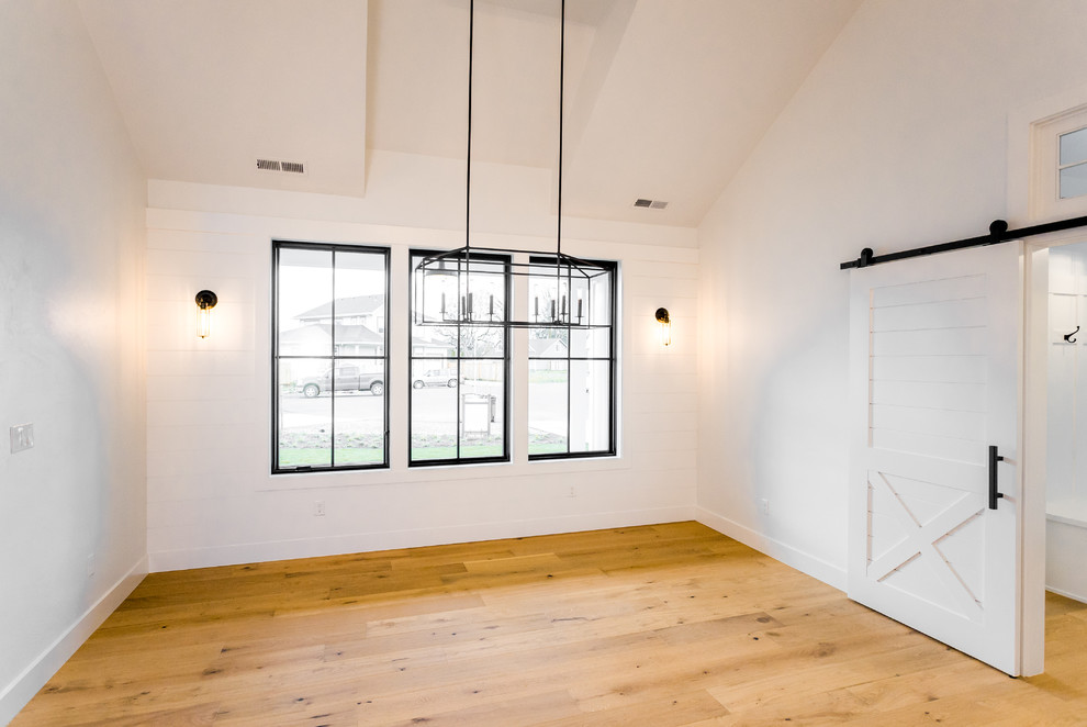 Idee per una sala da pranzo aperta verso la cucina country di medie dimensioni con pareti bianche, parquet chiaro e pavimento multicolore