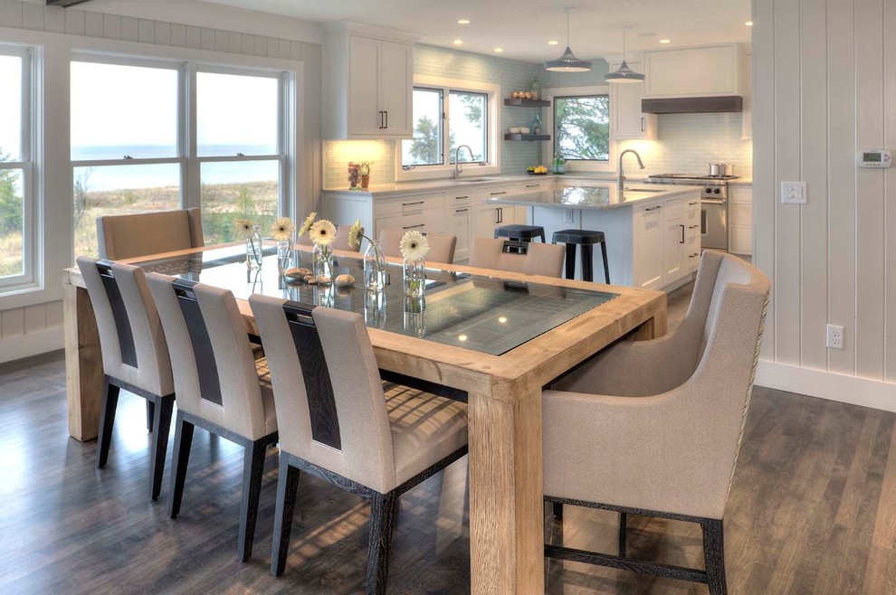 Idée de décoration pour une grande salle à manger ouverte sur la cuisine marine avec un mur blanc et un sol en bois brun.