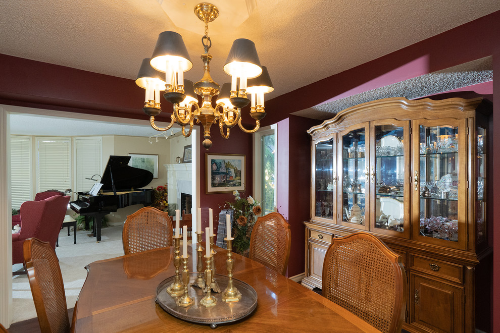 Medium sized traditional enclosed dining room in Calgary with a standard fireplace, a plastered fireplace surround, purple walls, medium hardwood flooring and brown floors.